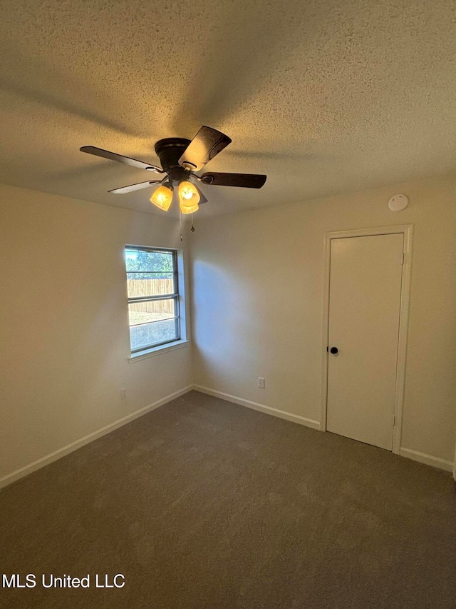 unfurnished room featuring dark colored carpet, a textured ceiling, and ceiling fan