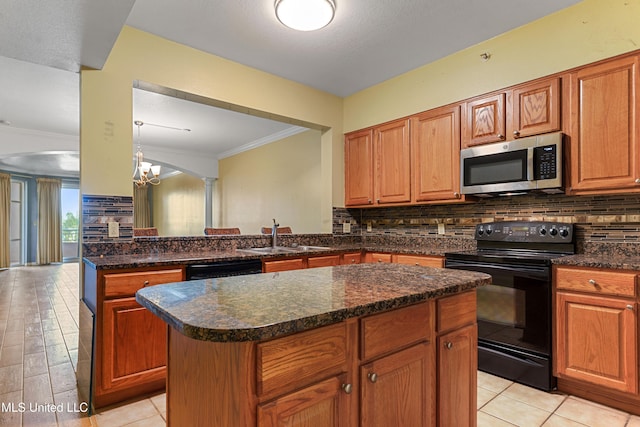 2230 Beach Dr Unit 205, Gulfport, MS 39507 - kitchen with black appliances, a sink, a center island, decorative backsplash, and crown molding