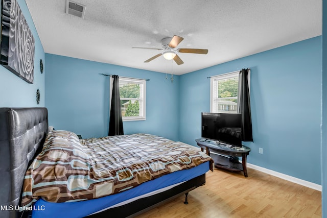 5608 Claresholm Dr, Gautier, MS 39553 - bedroom with wood finished floors, a textured ceiling, ceiling fan, and baseboards