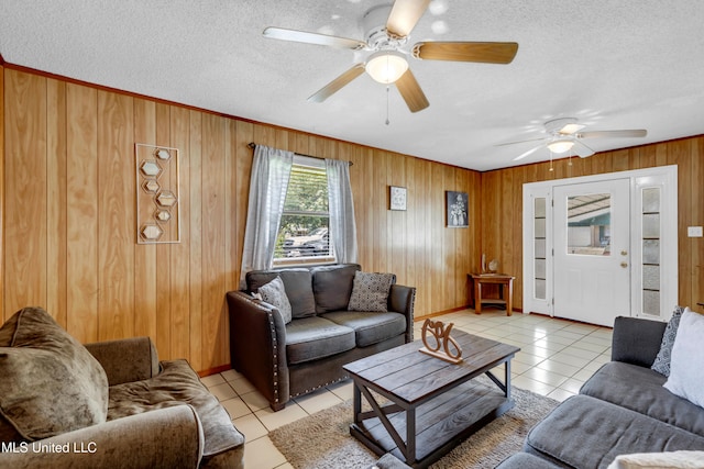 5608 Claresholm Dr, Gautier, MS 39553 - living area with light tile patterned floors, ceiling fan, wooden walls, a textured ceiling, and ornamental molding