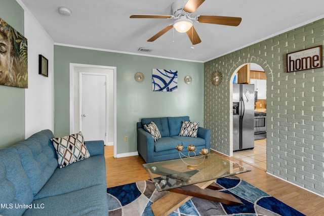5608 Claresholm Dr, Gautier, MS 39553 - living area featuring arched walkways, ornamental molding, a ceiling fan, wood finished floors, and baseboards