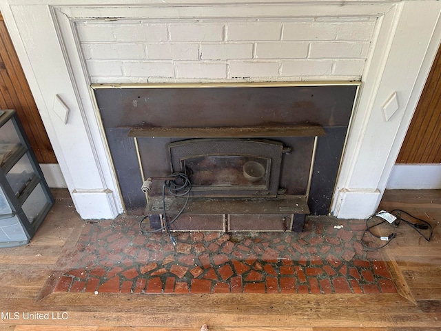 interior details with a wood stove and hardwood / wood-style floors