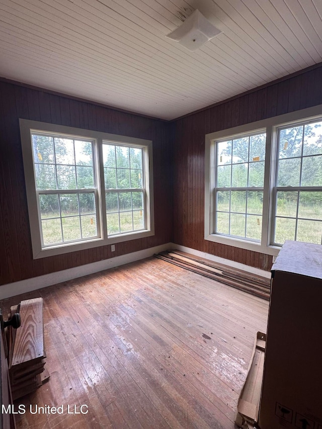 empty room featuring light hardwood / wood-style flooring and wooden walls