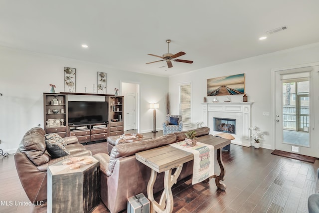 35 Enclave Cir, Ridgeland, MS 39157 - living room featuring ceiling fan, a glass covered fireplace, ornamental molding, dark wood-style flooring, and baseboards