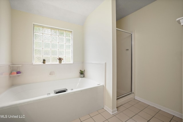 bathroom featuring a bath, a shower stall, tile patterned flooring, and lofted ceiling
