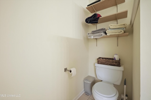 bathroom featuring toilet, tile patterned flooring, and baseboards