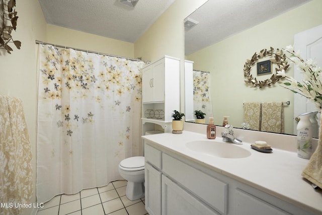 bathroom featuring vanity, toilet, tile patterned floors, and a textured ceiling