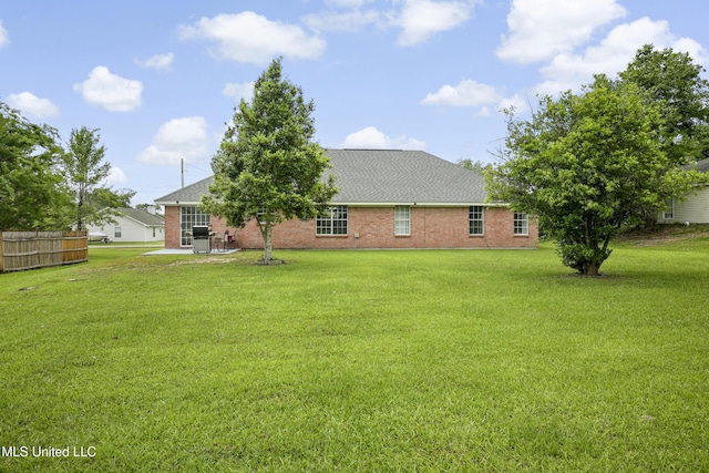 rear view of property featuring a patio area, brick siding, and a shingled roof