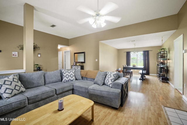 living room featuring light wood-style flooring, ceiling fan, and baseboards