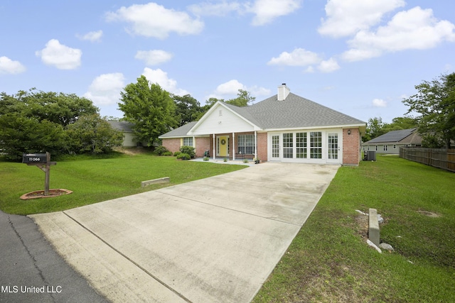 view of front of property featuring driveway, brick siding, a porch, a chimney, and cooling unit