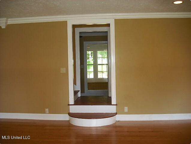 1105 Military Rd, Columbus, MS 39701 - spare room with ornamental molding, wood finished floors, and a textured ceiling