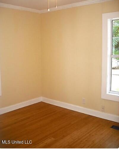 1105 Military Rd, Columbus, MS 39701 - spare room with ornamental molding and wood finished floors