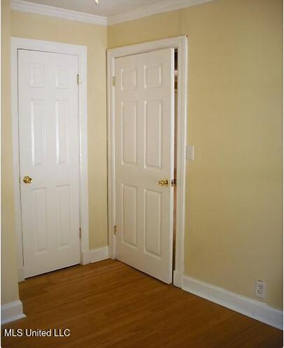 1105 Military Rd, Columbus, MS 39701 - unfurnished bedroom with crown molding and light wood-style flooring