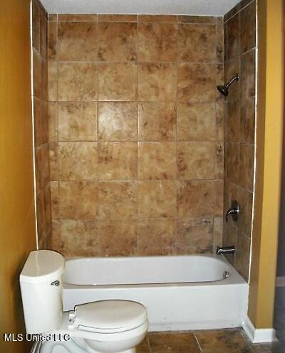 1105 Military Rd, Columbus, MS 39701 - bathroom with tile patterned floors and shower / washtub combination