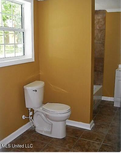 1105 Military Rd, Columbus, MS 39701 - full bathroom with tile patterned floors, a tub, vanity, and a shower