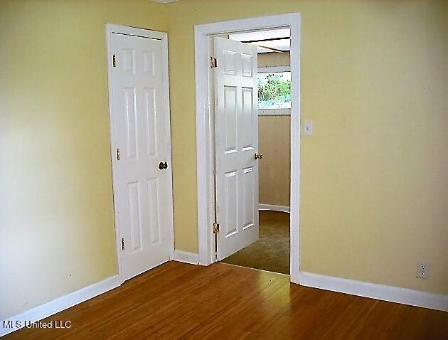 1105 Military Rd, Columbus, MS 39701 - unfurnished bedroom with baseboards and wood finished floors