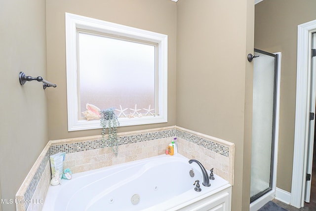 bathroom featuring a jetted tub and a shower stall