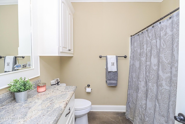 bathroom featuring toilet, vanity, baseboards, and tile patterned floors