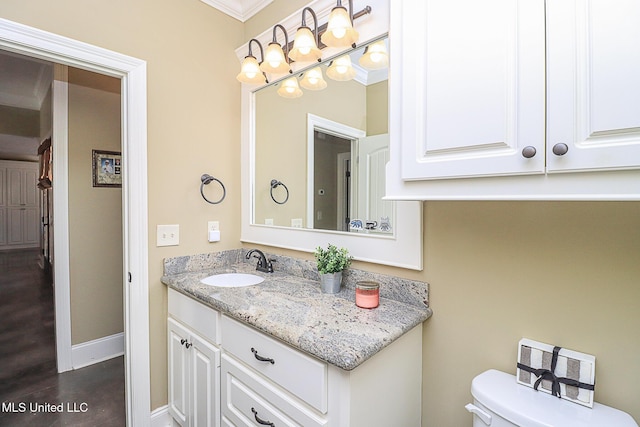 bathroom featuring wood finished floors, vanity, toilet, and baseboards