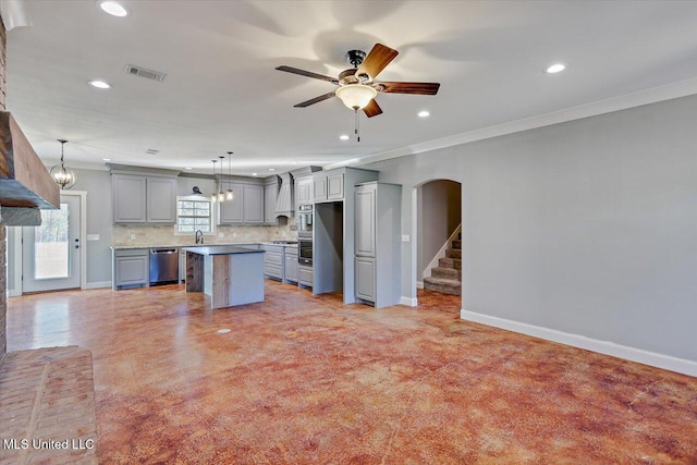 kitchen with tasteful backsplash, hanging light fixtures, a kitchen island, and stainless steel dishwasher