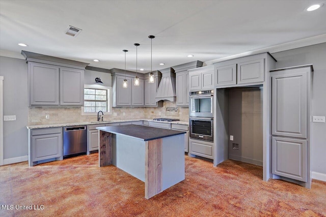 kitchen featuring appliances with stainless steel finishes, custom range hood, crown molding, sink, and a center island