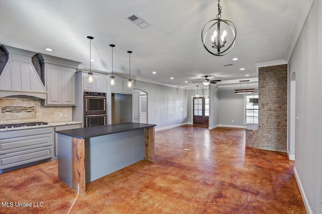 kitchen with gray cabinetry, stainless steel appliances, decorative backsplash, a kitchen island, and custom exhaust hood