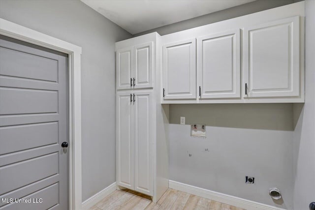 clothes washing area with washer hookup, electric dryer hookup, cabinets, and light hardwood / wood-style flooring