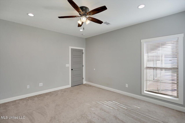 carpeted spare room featuring ceiling fan