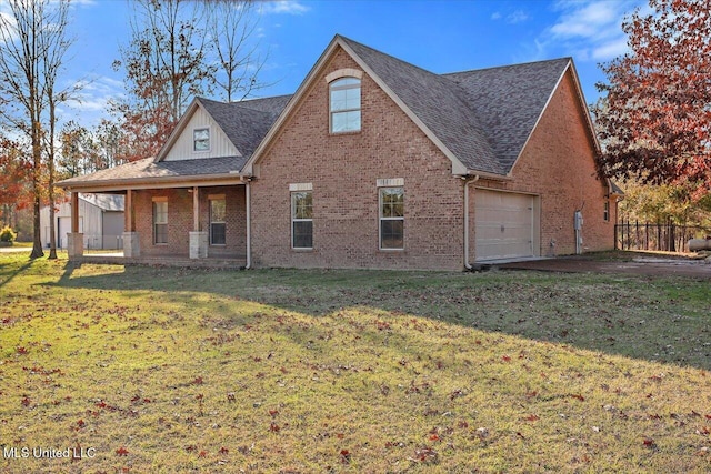 view of front facade featuring covered porch, a front yard, and a garage