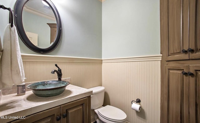 bathroom featuring vanity, toilet, and ornamental molding