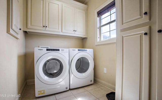 washroom with cabinets, light tile patterned floors, and washing machine and clothes dryer