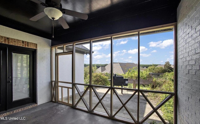 unfurnished sunroom featuring ceiling fan