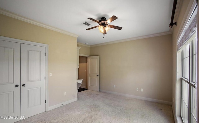 unfurnished bedroom featuring ceiling fan, a closet, light colored carpet, and ornamental molding