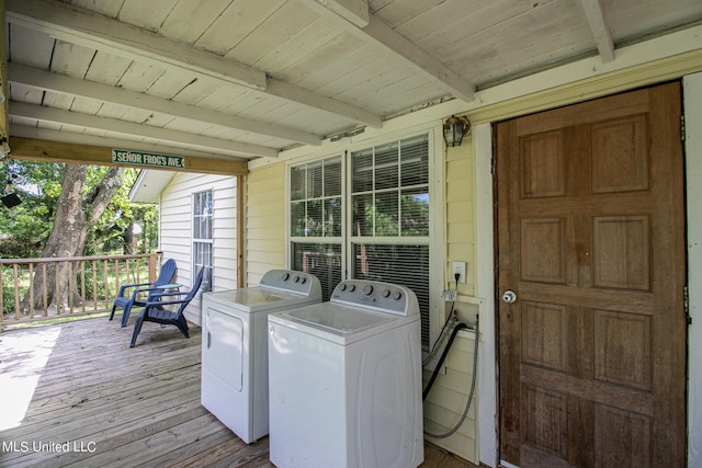 washroom with wooden walls, wooden ceiling, washing machine and dryer, and light wood-type flooring