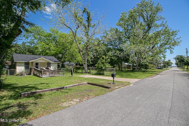exterior space with fence, a front yard, and a deck