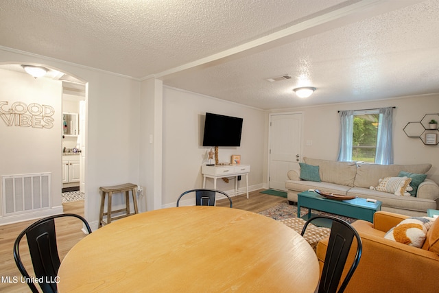 dining room with a textured ceiling and light hardwood / wood-style floors