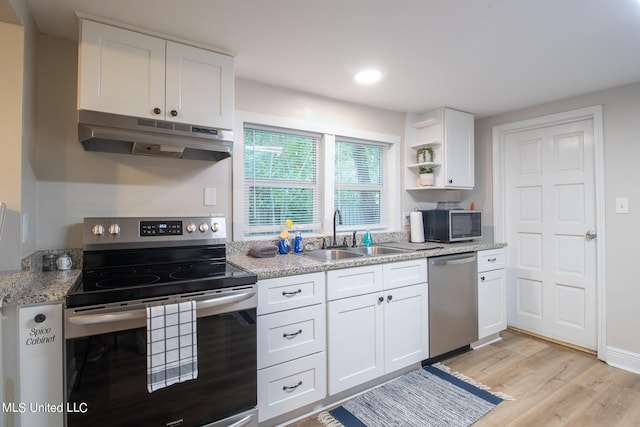 kitchen with appliances with stainless steel finishes, sink, light hardwood / wood-style floors, white cabinets, and light stone counters