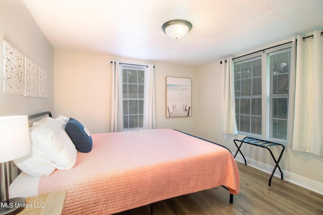 bedroom with baseboards and wood finished floors