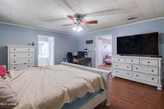 bedroom featuring connected bathroom, dark wood-style floors, crown molding, and visible vents
