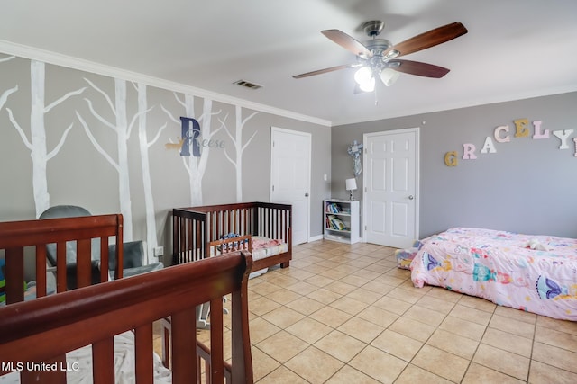 bedroom with crown molding, a ceiling fan, light tile patterned floors, baseboards, and visible vents