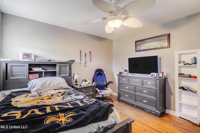 bedroom featuring baseboards, light wood-style floors, and a ceiling fan