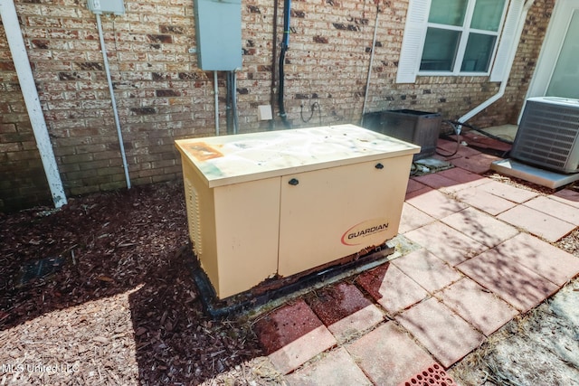 exterior details featuring brick siding, a hot tub, a power unit, and central air condition unit