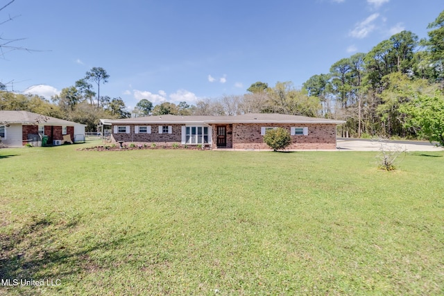single story home featuring brick siding, driveway, and a front lawn