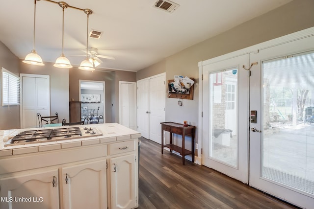kitchen with a ceiling fan, tile counters, gas cooktop, and visible vents