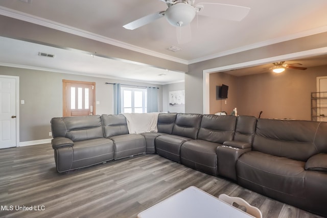 living area with ceiling fan, visible vents, ornamental molding, and wood finished floors