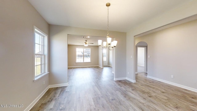 unfurnished dining area with light wood-type flooring and an inviting chandelier