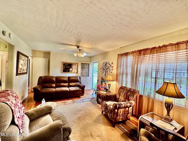 living room featuring a textured ceiling, hardwood / wood-style flooring, and ceiling fan