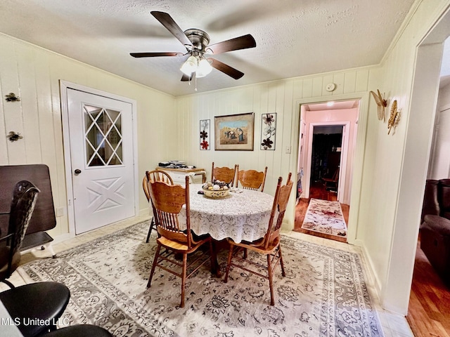 dining area with ceiling fan, crown molding, light hardwood / wood-style floors, and a textured ceiling