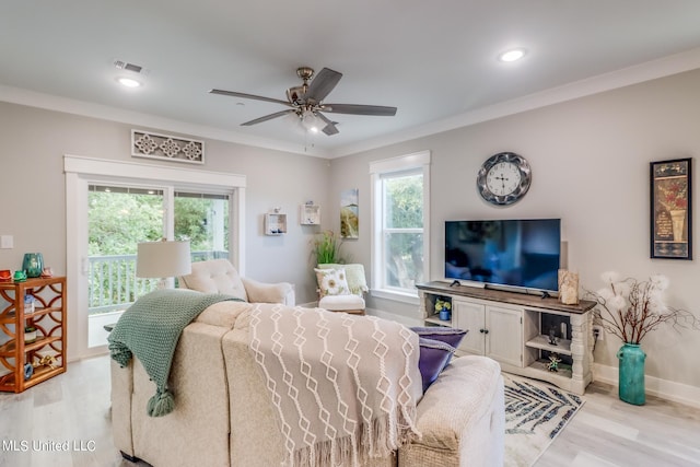 living room featuring ornamental molding, light hardwood / wood-style floors, and ceiling fan