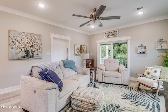 living room featuring crown molding, light wood-type flooring, and ceiling fan